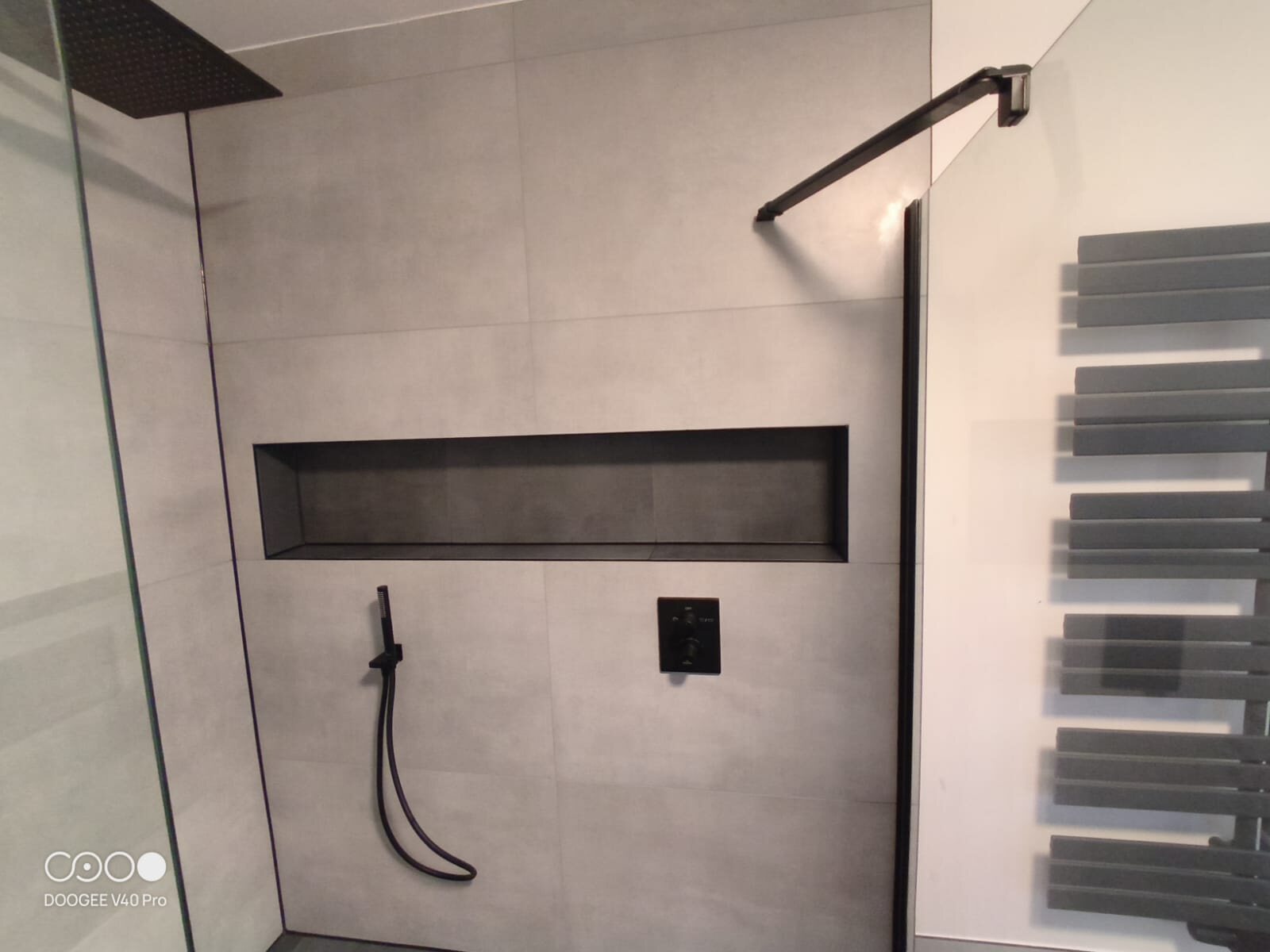 Freistehende Mineralguss-Badewanne am Fenster mit schwarzer Standarmatur