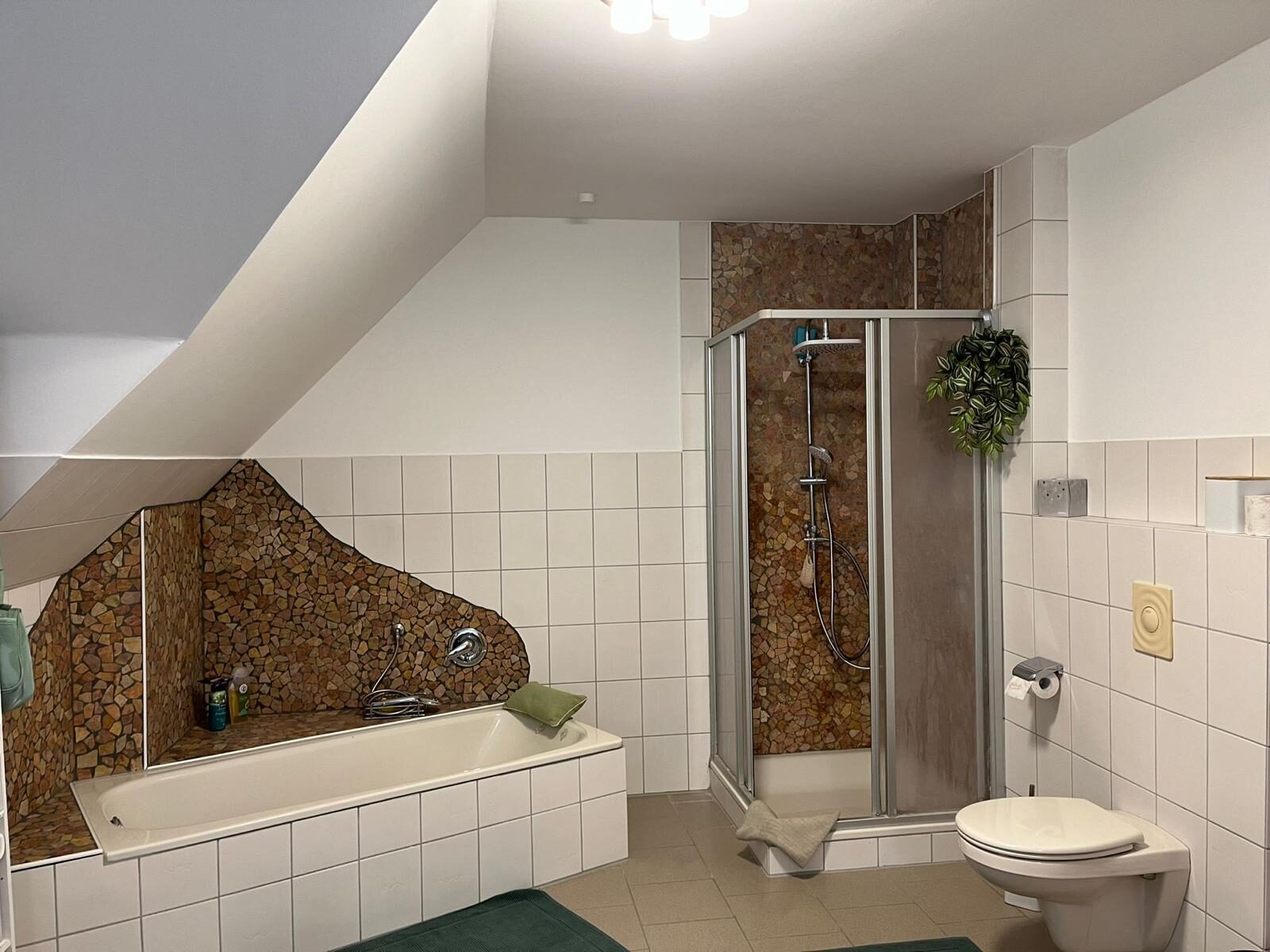 Wanne und enge Duschkabine mit Bruchstein-Mosaik