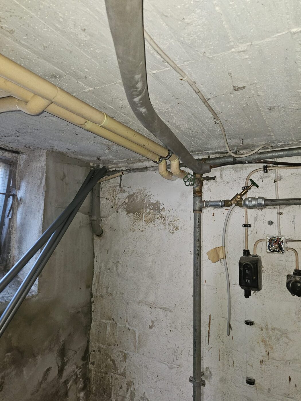 Neue Abwasserleitung an der Kellerdecke nach der Kernbohrung